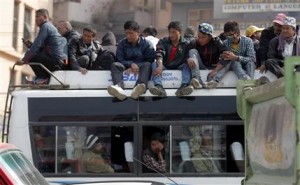In this Nov. 27, 2015 photo, Nepalese people sit on the top of a crowded public bus in Kathmandu, Nepal. An ethnic groups blockade of a key border point with India is leaving Nepal with only about 15 percent of its normal supply of gasoline, diesel and cooking fuel, and creating shortages of other goods including food and medicine. (AP Photo/Niranjan Shrestha)