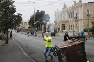 This Friday, Oct. 23, 2015 photograph shows Palestinians clashing with Israeli troops in front of the Intercontinental hotel in the West Bank city of Bethlehem. The century-old Jacir Palace hotel, with its soaring stone archways and wrought iron balconies, was once a symbol of Bethlehems wealth and tourism potential. Today, the property reflects the citys dour mood ahead of the crucial Christmas season after months of unrest that has taken more than 100 lives, including a Palestinian waiter from the hotel. (AP Photo/Nasser Shiyoukhi)