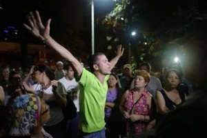 Opposition supporters celebrates the closing of a polling station during congressional elections in Caracas, Venezuela, Sunday, Dec. 6, 2015. Some members of the opposition are angry after elections officials ordered polling centers to stay open for an extra hour, even if no one was standing in line to vote. Government opponents mobbed some voting stations demanding that the National Guard stick to the original schedule of closing at 6 p.m. (AP Photo/Ariana Cubillos)