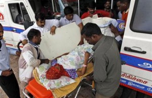 In this Friday, Dec. 4, 2015 photo, a patient is shifted to an ambulance after the hospital she was being treated in had to be shut down because of power failure and being inundated with floodwaters in Chennai, in the southern Indian state of Tamil Nadu. Officials say 18 patients who were in the intensive care unit of this hospital died when a power outage affected ventilators in the hospital, after rain waters knocked out generators of the building.  (AP Photo/Arun Sankar K)