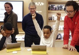 FILE - In this Wednesday, Dec. 9, 2015, file photo, third-grader Jaysean Erby raises his hands as he solves a coding problem as Apple CEO Tim Cook watches from behind during a coding workshop at an Apple Store, in New York. Theres a nationwide push to improve computer literacy in elementary school, and entrepreneurs are jumping aboard. You really want kids to learn these building blocks as young as possible and then build on them, said Cook. (AP Photo/Mark Lennihan, File)